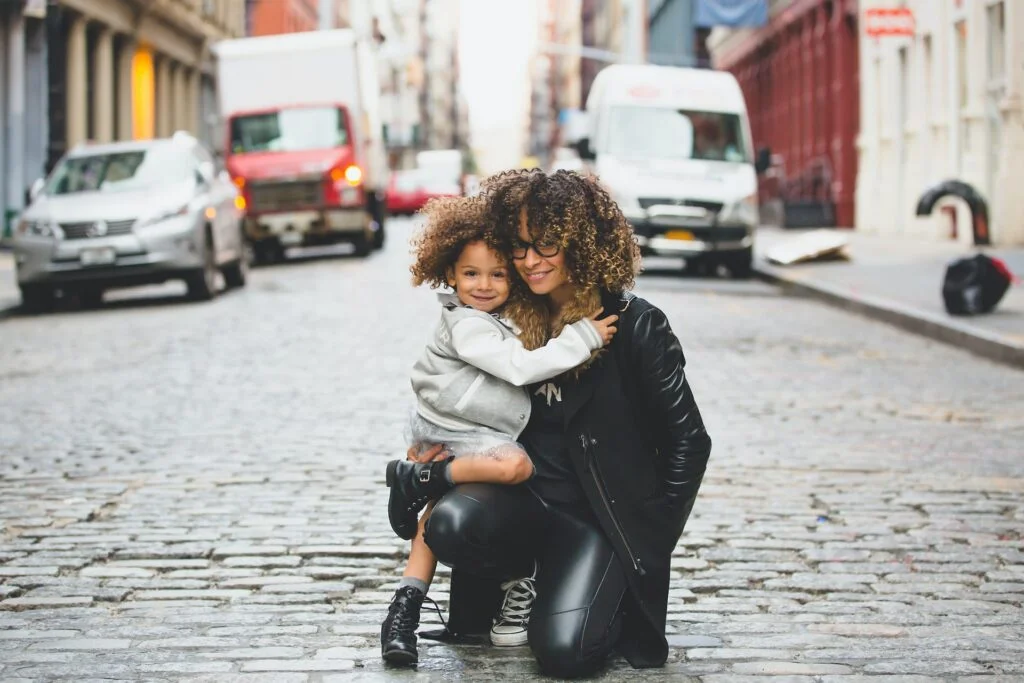 A mother embracing her child outdoors